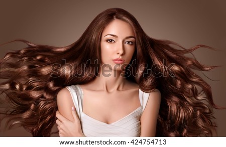 Model with long  brown hair. Waves Curls Hairstyle. Hair Salon.