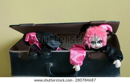 joker doll on the old suitcase