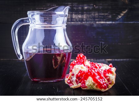Pomegranate juice and pomegranate parts on a black background