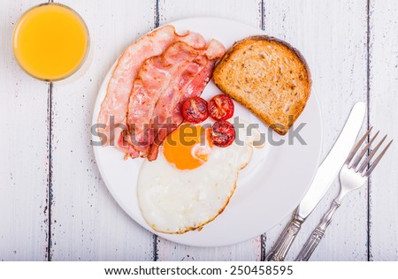 Tasty dish with the traditional bacon and eggs served with toast