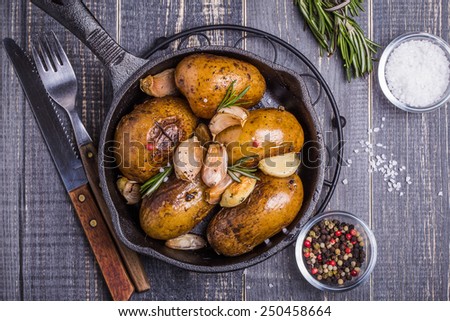 Country style potatoes with rosemary, garlic on a wooden dark background