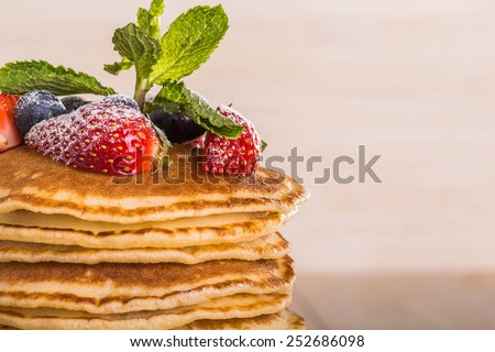 Homemade pancakes with berries and fruit on a white background