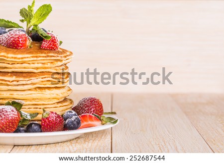 Homemade pancakes with berries and fruit on a white background