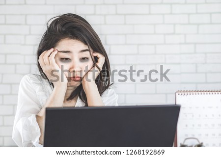 sleepless Asian woman feeling tired and sleepy at workplace eyes looking at computer on desk lazy to work