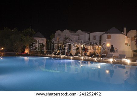 A pretty swimming pool in night at a local resort Santorini , Greece