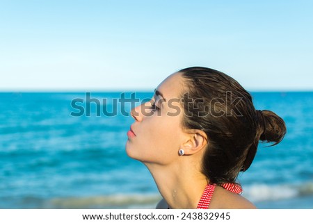 Woman relaxing at the sea, headshot, side-face