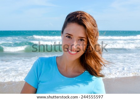 Young attractive woman smiling at the beach, headshot