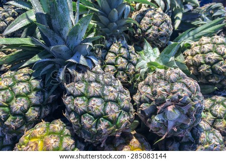 Pile of Pineapples in Fruit Stall at Local Market Background Texture