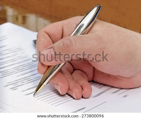 businessman signs a contract / partially out of focus, focus on the hand and pen