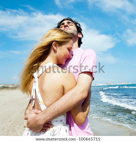 Young couple at beach, embracing, side view. Natural emotions. Happy life