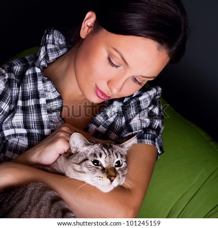 Happy young woman with cat, relaxed on the beanbag couch.g woman with cat, relaxed on the beanbag couch.