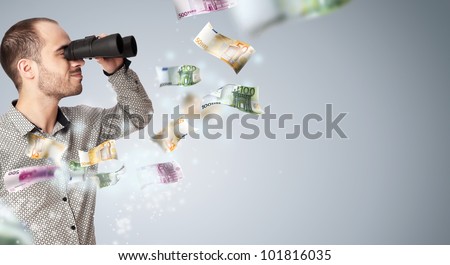 Portrait of a young business man with binoculars looking to the future. Money rain surrounding him