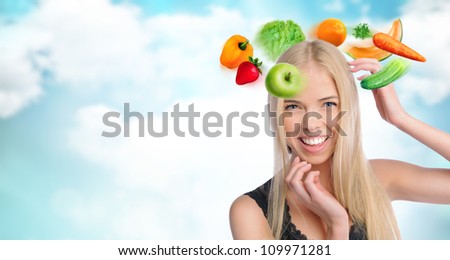 Young beautiful woman with vegetables, berries and fruits flying around her head. Healthy food and lifestyle concept