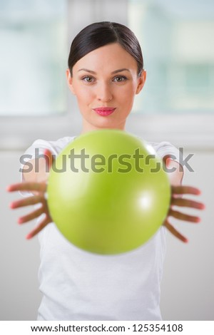 Portrait of fit and healthy gym woman with ball at fitness club or at home positive and happy doing exercises
