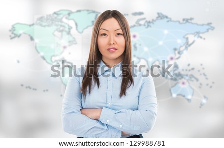 Portrait of young woman standing in front of big world map and looking at camera. Server locations and actual online connections are displayed on virtual map. Hosting provider concept.