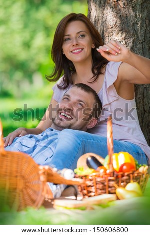 Adult couple picnicking in the park under the tree