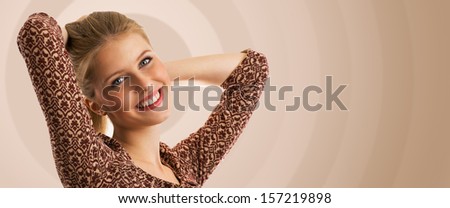 Young beautiful teenage girl dancing over creative beige background and looking at camera