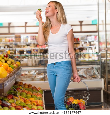 Casual woman grocery shopping at organic food section with basket