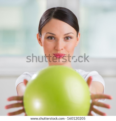 Portrait of fit and healthy gym woman with ball at fitness club or at home positive and happy doing exercises