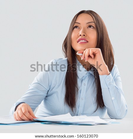 Closeup portrait of a cheerful young businesswoman doing paperwork