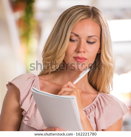 Shopping list - woman using shopping list at grocery store