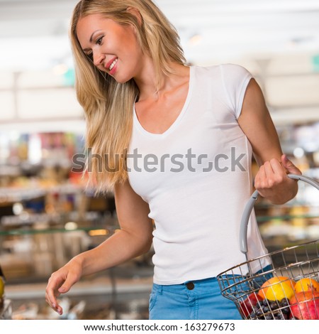 Casual woman grocery shopping at organic food section with basket