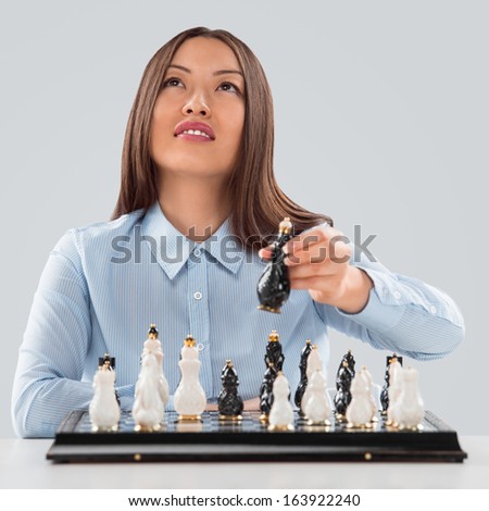 Business woman moving chess figure - strategy or leadership concept