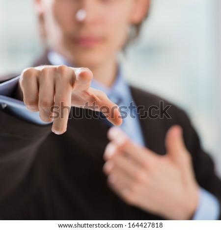 Portrait of adult business man pointing at you at his office