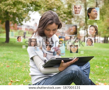 Young woman using tablet computer with many different people\'s faces around her. Technology social media network of friends and communication.
