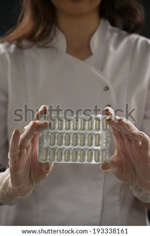 Unrecognizable female doctor holding blister with pills
