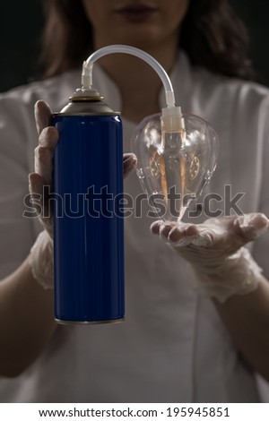 Unrecognizable female doctor holding can with oxygen and breathing through the mask