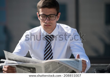 Businessman reading newspaper outdoor