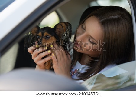 Woman and dog in car on summer travel. Funny dog traveling. Vacation with pet concept.