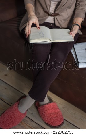 Unrecognizable thinking business woman holding notepad or organizer and planning at her office