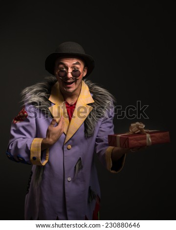 Clown man with Christmas gift box on black background