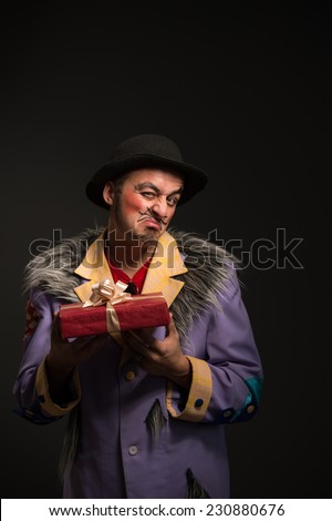 Clown man with Christmas gift box on black background