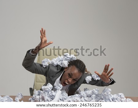 African business woman is tired of work . Sitting in front of crumpled paper pile . Unhappy with cv