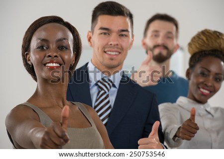 Business team celebrating a triumph with thumbs up