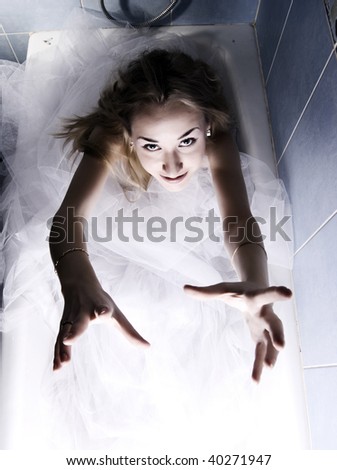Beautiful blond bride wearing wedding dress posing in bathroom help needed