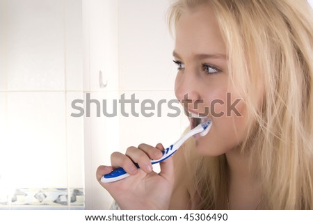 Portrait of a beautiful young blond fashionable woman washing up in bathroom