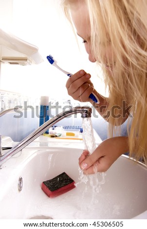 Portrait of a beautiful young blond fashionable woman washing up in bathroom