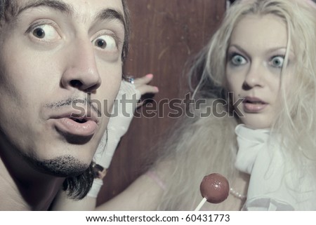 Young attractive trash man and woman making madness inside vintage lift. Halloween theme