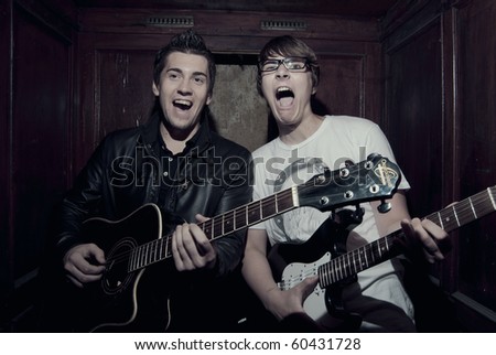 Two young musicians playing music inside vintage elevator