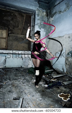 Young ballerina woman inside empty grunge room