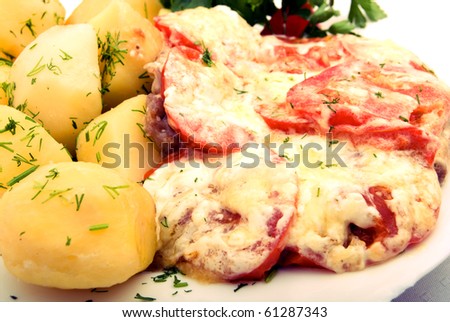 Dinner meal. Hot boiled potato with melting cheese sauce and tomato