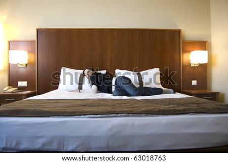 Young woman on bed in hotel room with nice interior design