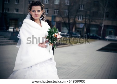 Portrait of young beautiful woman bride outdoor with lily bouquet wearing white decorated dress
