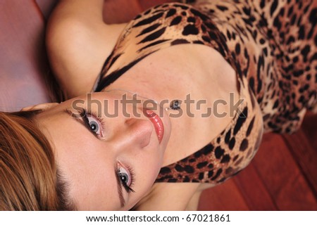 Portrait of adult woman posing on camera laying on wooden stairs indoor