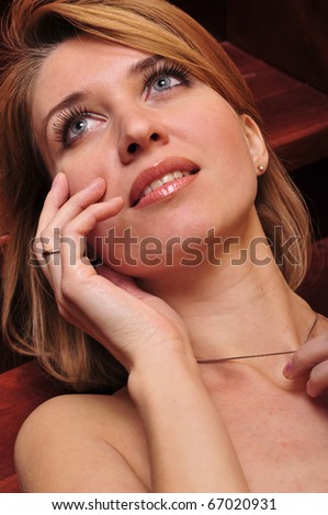 Portrait of adult beautiful woman laying on stairs. Beauty closeup