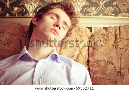 Portrait of young handsome guy sleeping in his apartment at night after hard day
